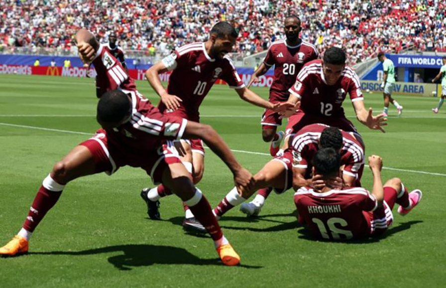 Jogadores da seleção do Qatar celebram juntos no relvado após marcar um golo, refletindo o momento decisivo do empate frente à Suíça no Mundial2026.