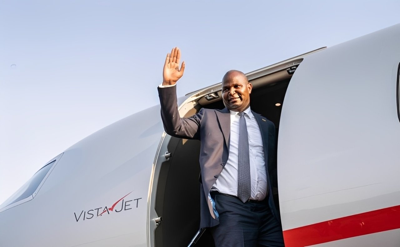 Presidente de Moçambique a sair de um avião e a acenar, simbolizando a chegada da delegação moçambicana a Bruxelas para o evento RENMOZ in Europe sobre energias renováveis.